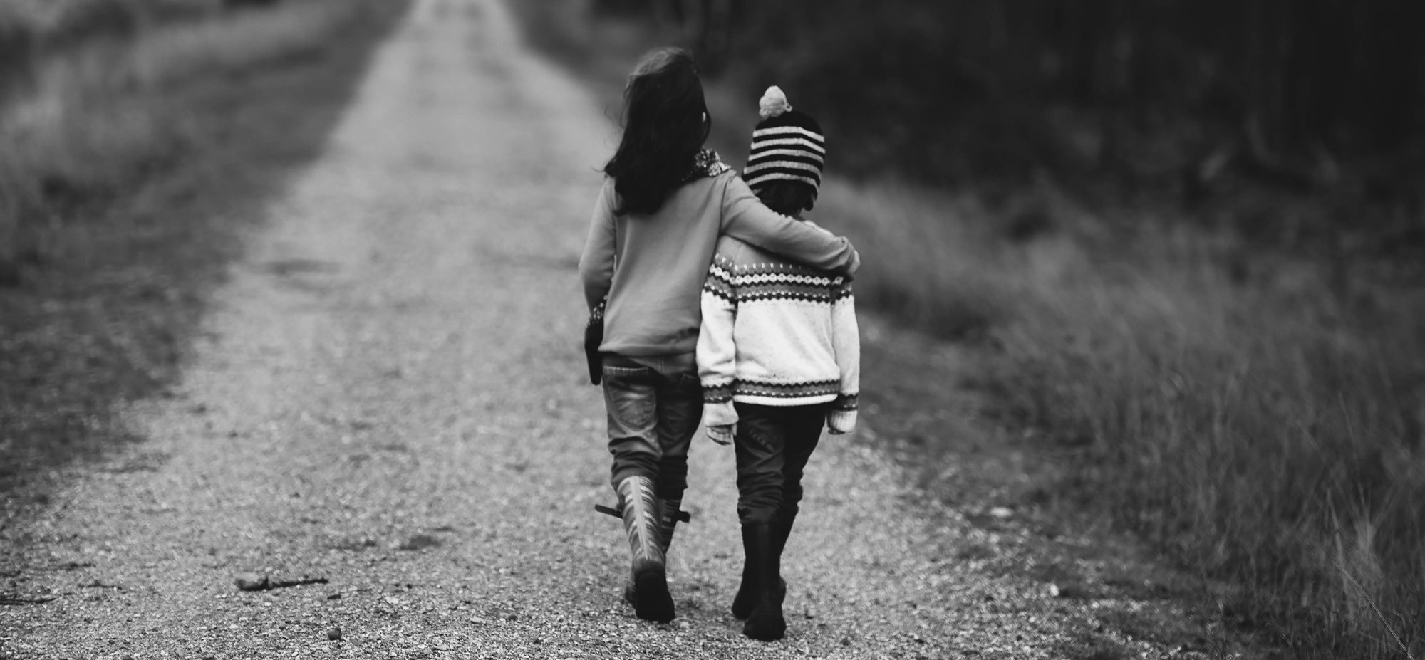 two children walking supporting each other