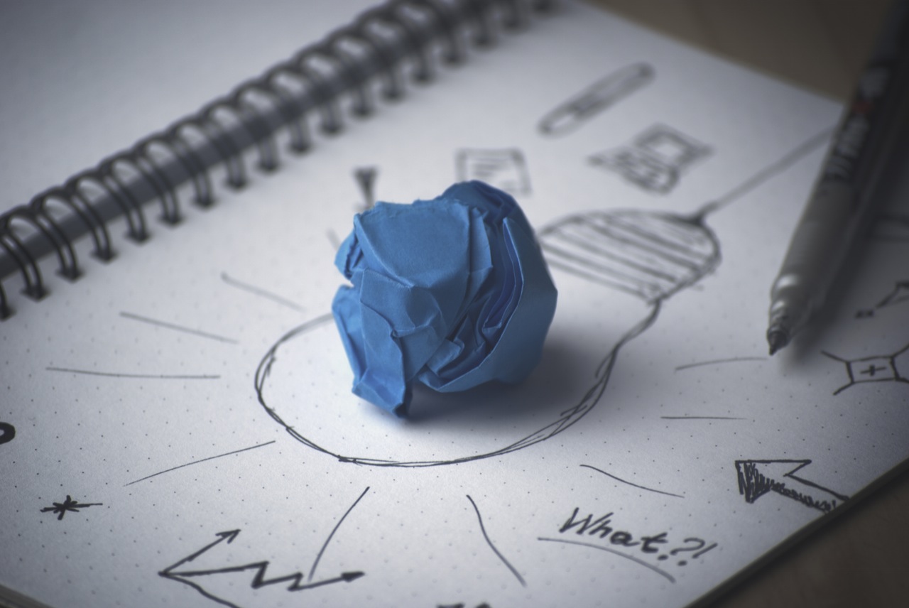 Scrunched up paper lighting up an idea bulb